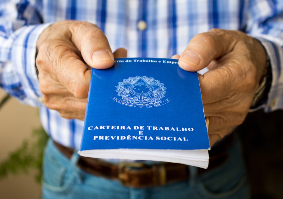 Homem idoso segurando carteira de trabalho