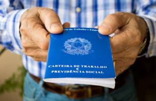 Homem idoso segurando carteira de trabalho