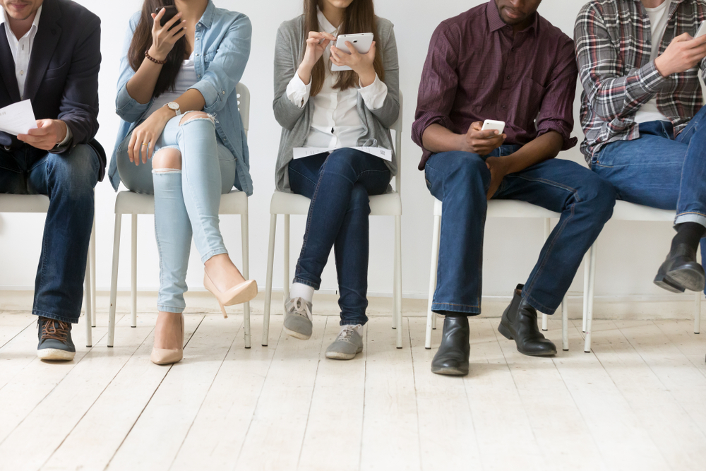 Cinco pessoas sentadas à espera da entrevista de emprego