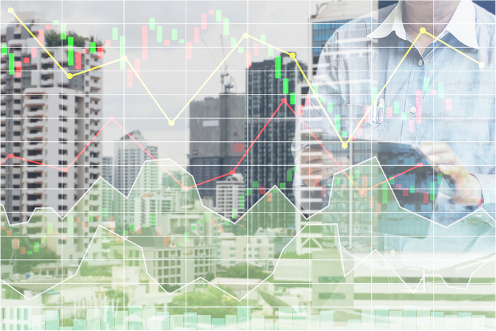 Businessman standing and operate tablet to control and connect big data of real estate sector stock market index with chart and graph background.