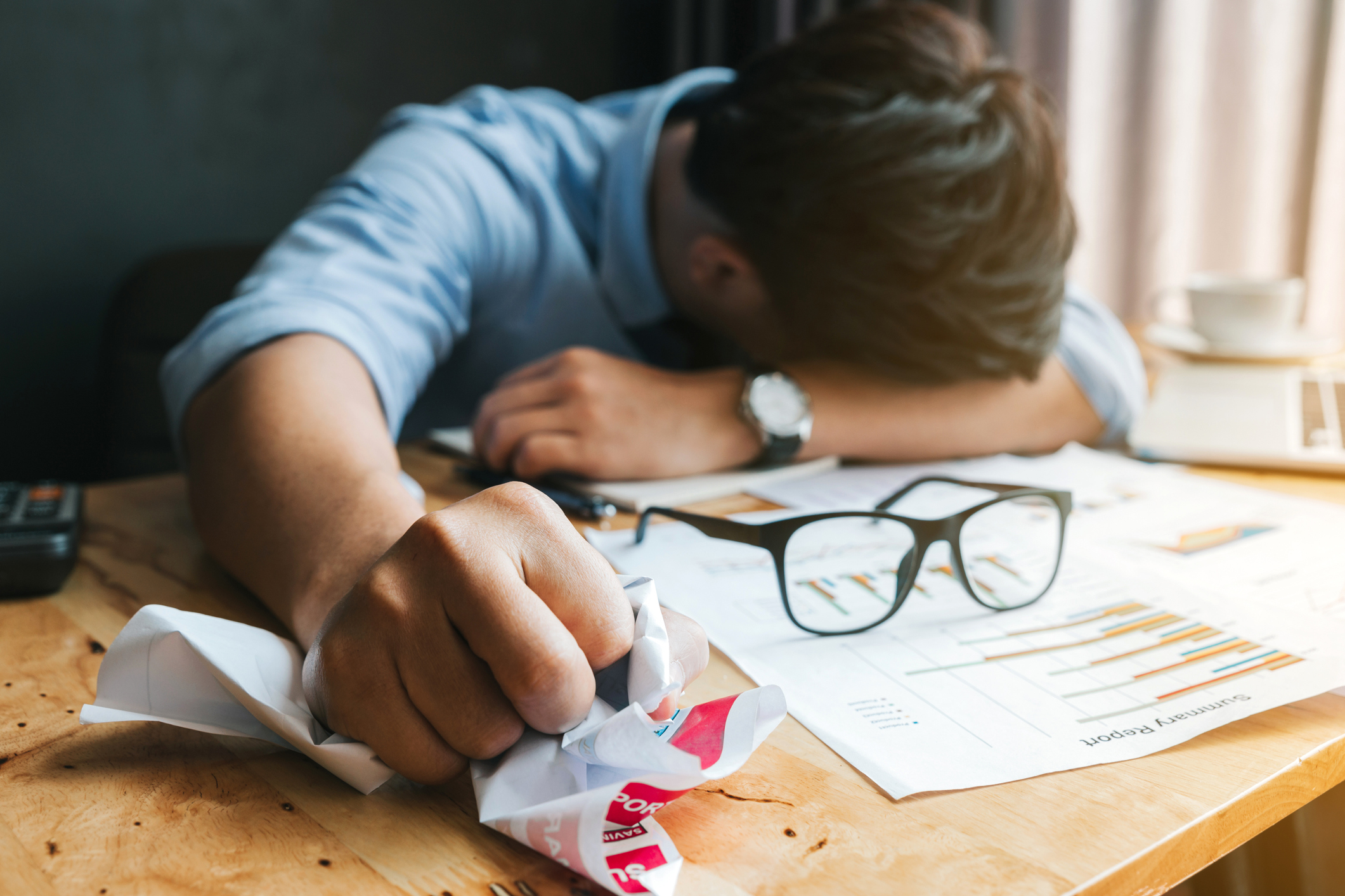 Stress or failure concept.Angry and tired businessman crumpling papers in the office.