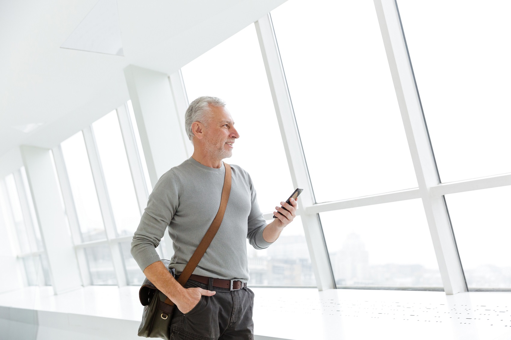 Homem grisalho mexendo no celular, homem mais velho