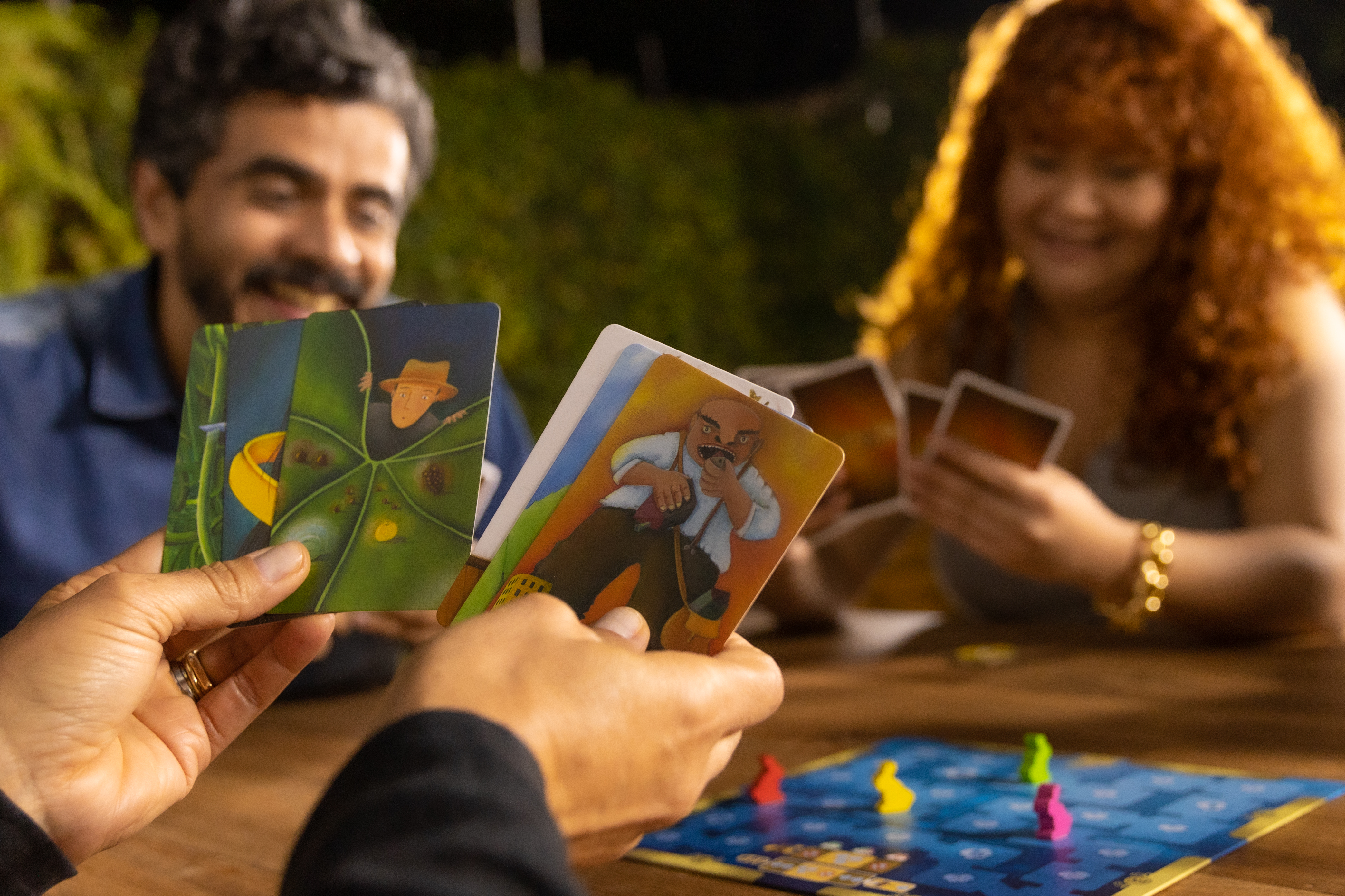 Pessoas alegres desfrutando de jogo de cartas com táticas e dados