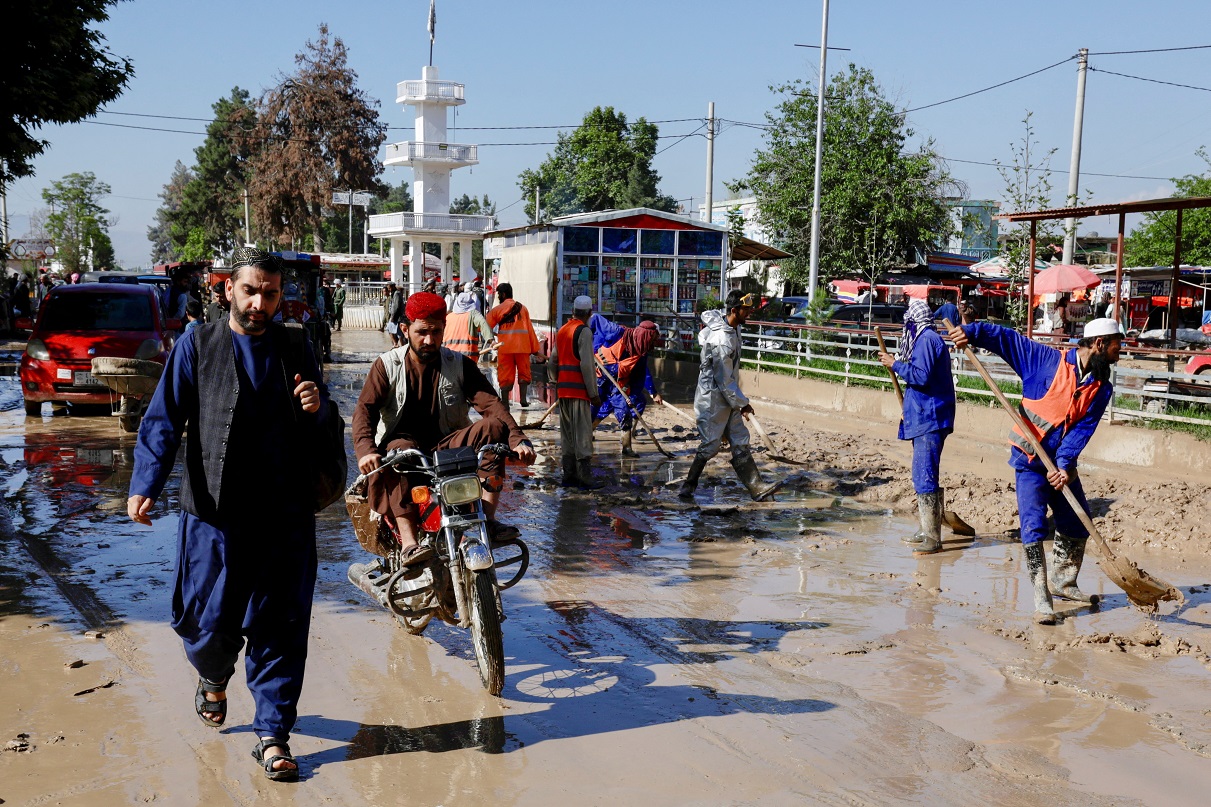 Tráfego avança enquanto os trabalhadores municipais removem os destroços das ruas após as enchentes no distrito de Sheikh Jalal, província de Baghlan, Afeganistão (REUTERS/Sayed Hassib)