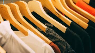 Cabides com roupas em mostruário de loja de moda (Foto: Kai Pilger/Pexels)