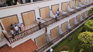 Trabalhadores instalando tábuas de madeira para cobrir portas de vidro em um hotel antes da chegada do furacão Beryl, em Playa del Carmen, México, em 3 de julho de 2024. REUTERS/Jose Luis Gonzalez