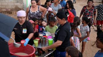 Pessoas recebem alimentos de Carolina Leal, diretora e fundadora da fundação Alimentando Suenos, em Maracaibo, Venezuela, em 12 de junho de 2024 REUTERS/Gaby Oraa