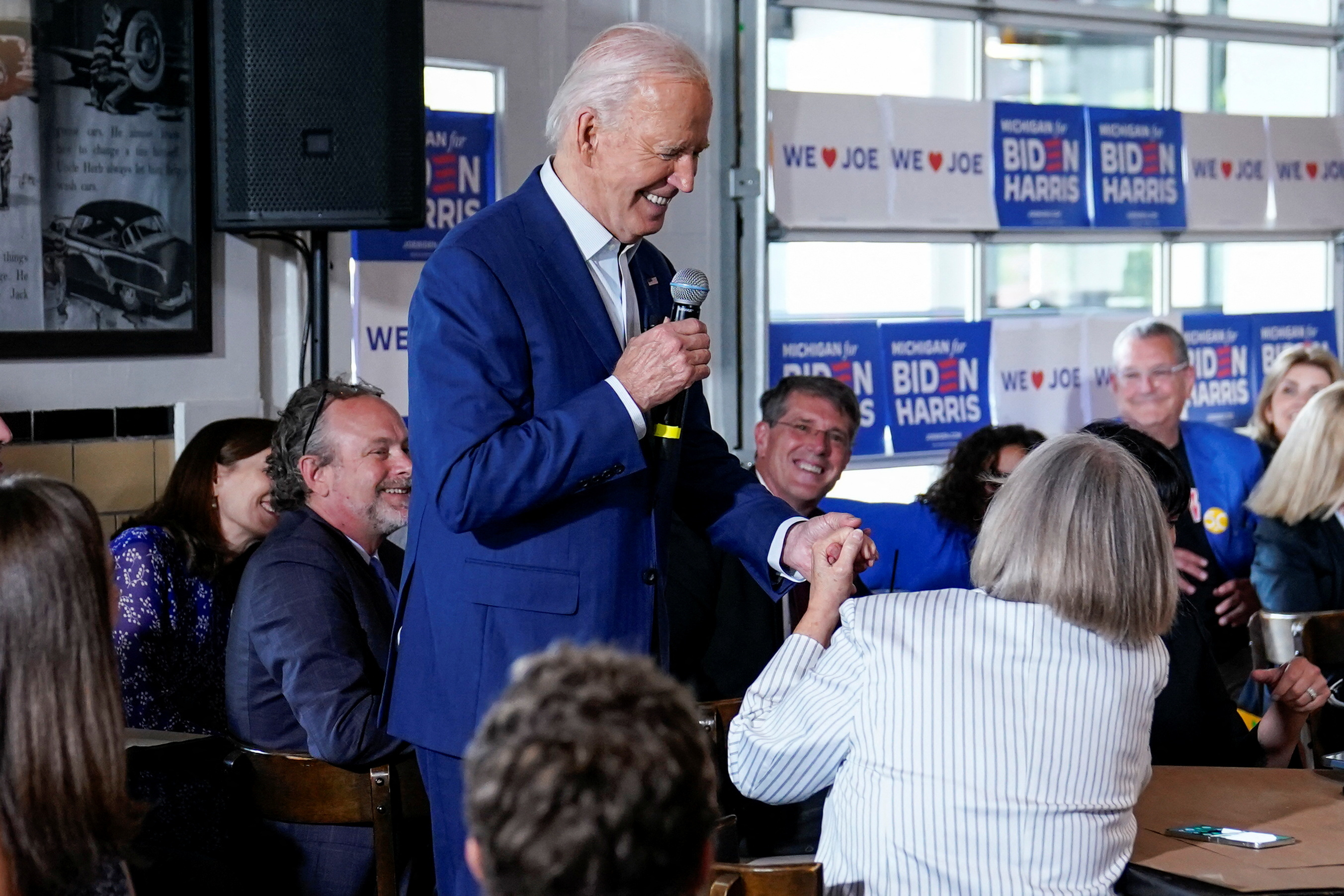 O presidente dos Estados Unidos, Joe Biden, segura a mão de uma mulher durante sua visita a restaurante no Michigan, EUA, em 12 de julho de 2024. REUTERS/Elizabeth Frantz