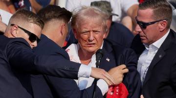 Donald Trump é auxiliado por pessoal do Serviço Secreto dos EUA após o tiroteio durante um comício de campanha no Butler Farm Show