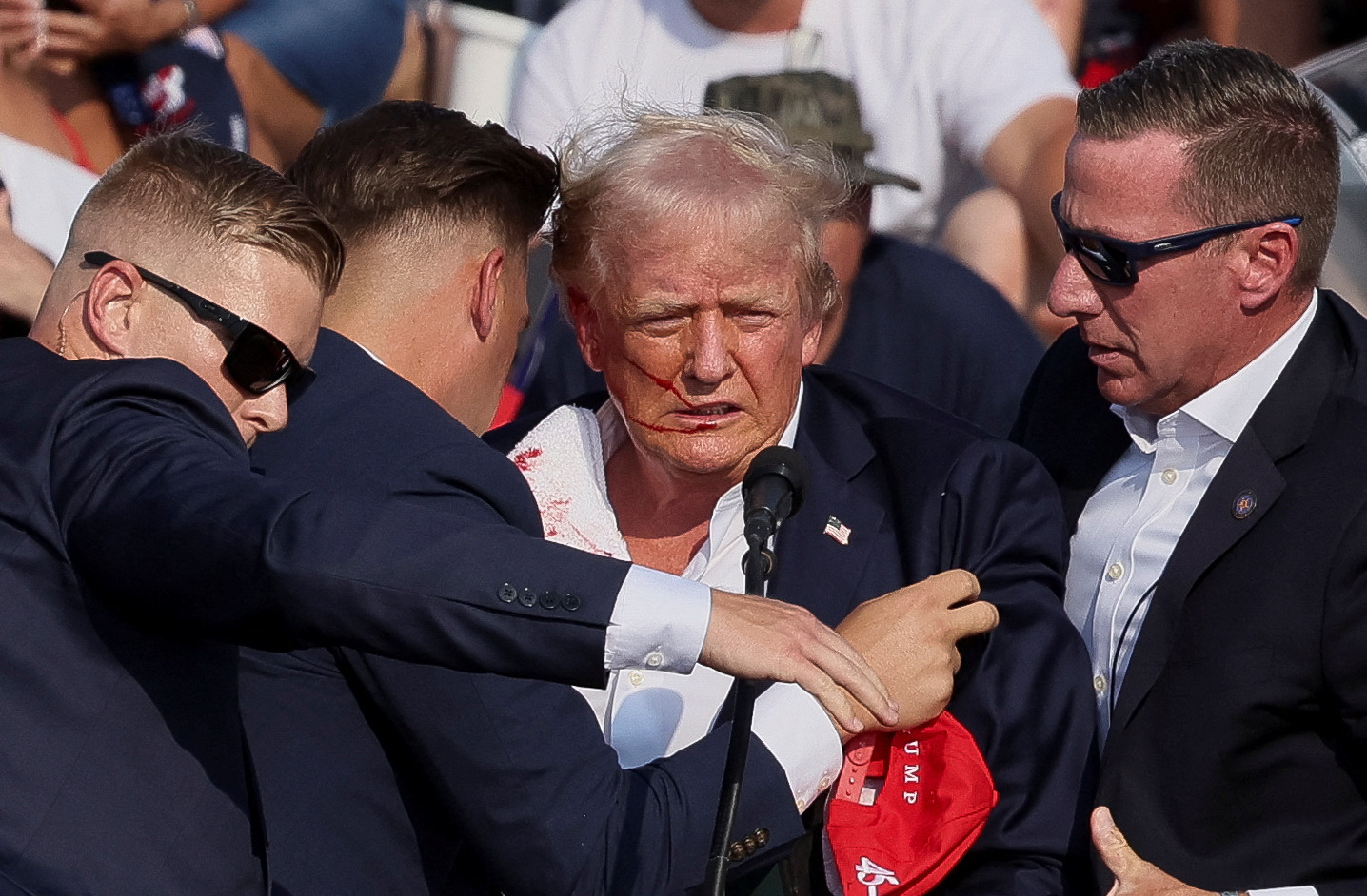 O candidato presidencial republicano e ex-presidente dos EUA, Donald Trump, é auxiliado por pessoal do Serviço Secreto dos EUA após o tiroteio durante um comício de campanha no Butler Farm Show em Butler, Pensilvânia, EUA, 13 de julho de 2024 (REUTERS/Brendan McDermid)