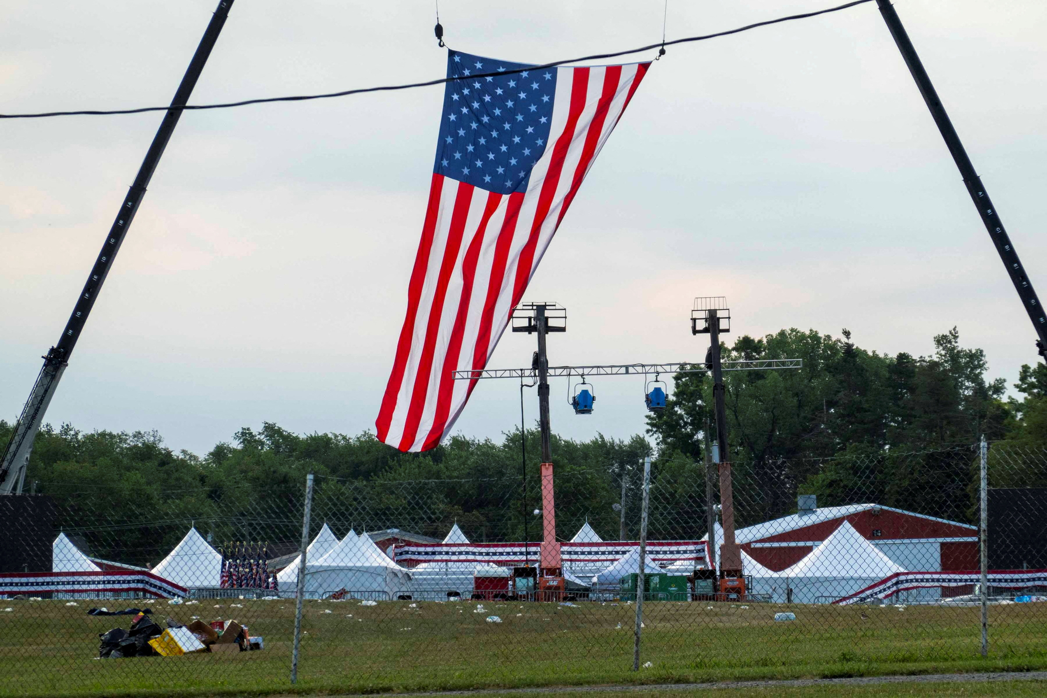 Bandeira pendurada sobre o palco no local do evento onde o comício foi realizado, durante a investigação policial sobre os tiros em um comício de campanha do candidato presidencial republicano e ex-presidente dos EUA, Donald Trump, em Butler, Pensilvânia, EUA (REUTERS/Carlos Osorio)