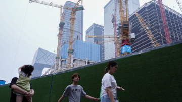 Pessoas caminham em área de construção de Pequim, na China