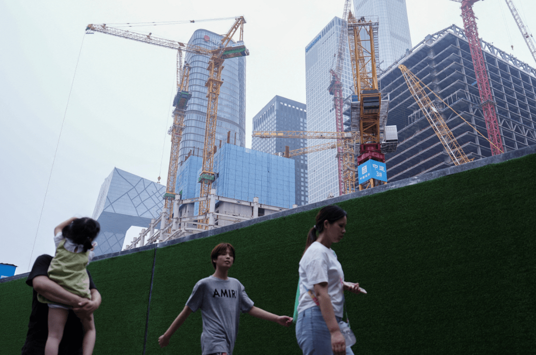 Pessoas caminham em área de construção de Pequim, na China 14/07/2024 REUTERS/Tingshu Wang

