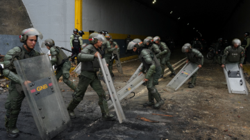 Membros da Guarda Nacional Bolivariana da Venezuela usam seus escudos após um protesto de apoiadores da oposição venezuelana