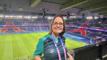 mulher voluntária nas Olímpiadas de Paris 2024 dentro de estádio de futebol