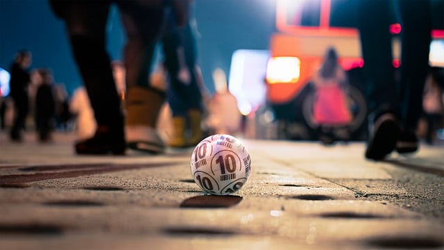 Bola branca com número para sorteio de loteria em perspectiva em uma rua com pessoas andando ao fundo