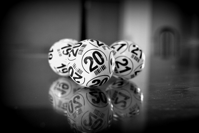 Foto em preto e branco de bolas com números para sorteio de loterias
