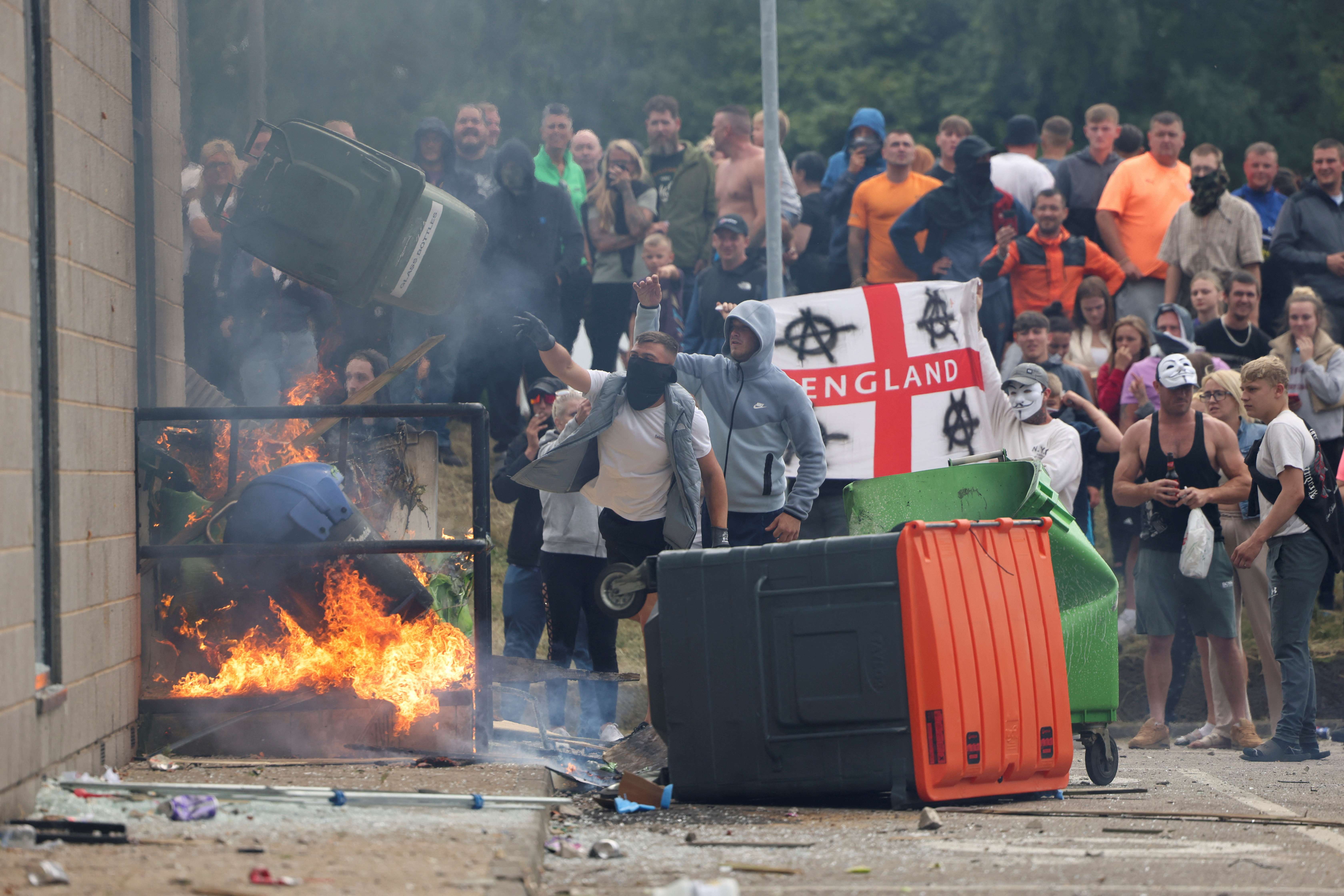 Manifestantes jogam uma lata de lixo durante um protesto anti-imigração, em Rotherham, na Grã-Bretanha 04/08/2024 (Foto: Hollie Adams/Reuters)
