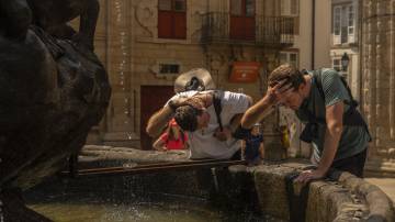 Visitantes se refrescam com água de uma fonte na Praça Platerias durante altas temperaturas em Santiago de Compostela, Espanha, no sábado, 10 de agosto de 2024. O calor extremo está cobrindo a Espanha e partes do sul da Europa, enquanto as temperaturas do mar aumentam em partes do Mediterrâneo (Bloomberg)