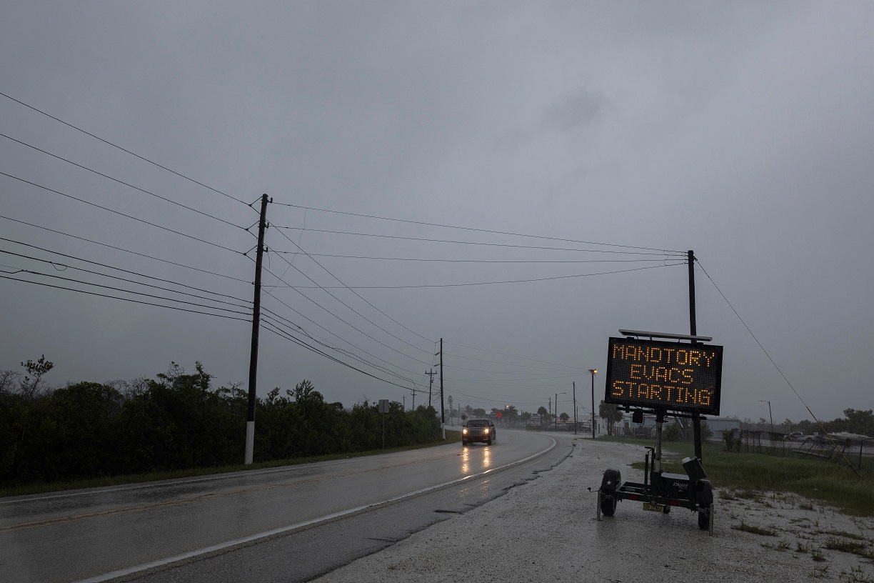 Um motorista dirige perto de um sinal que avisa sobre evacuações obrigatórias antes da chegada do furacão Milton em Matlacha, Flórida, EUA, em 9 de outubro de 2024. REUTERS/Ricardo Arduengo