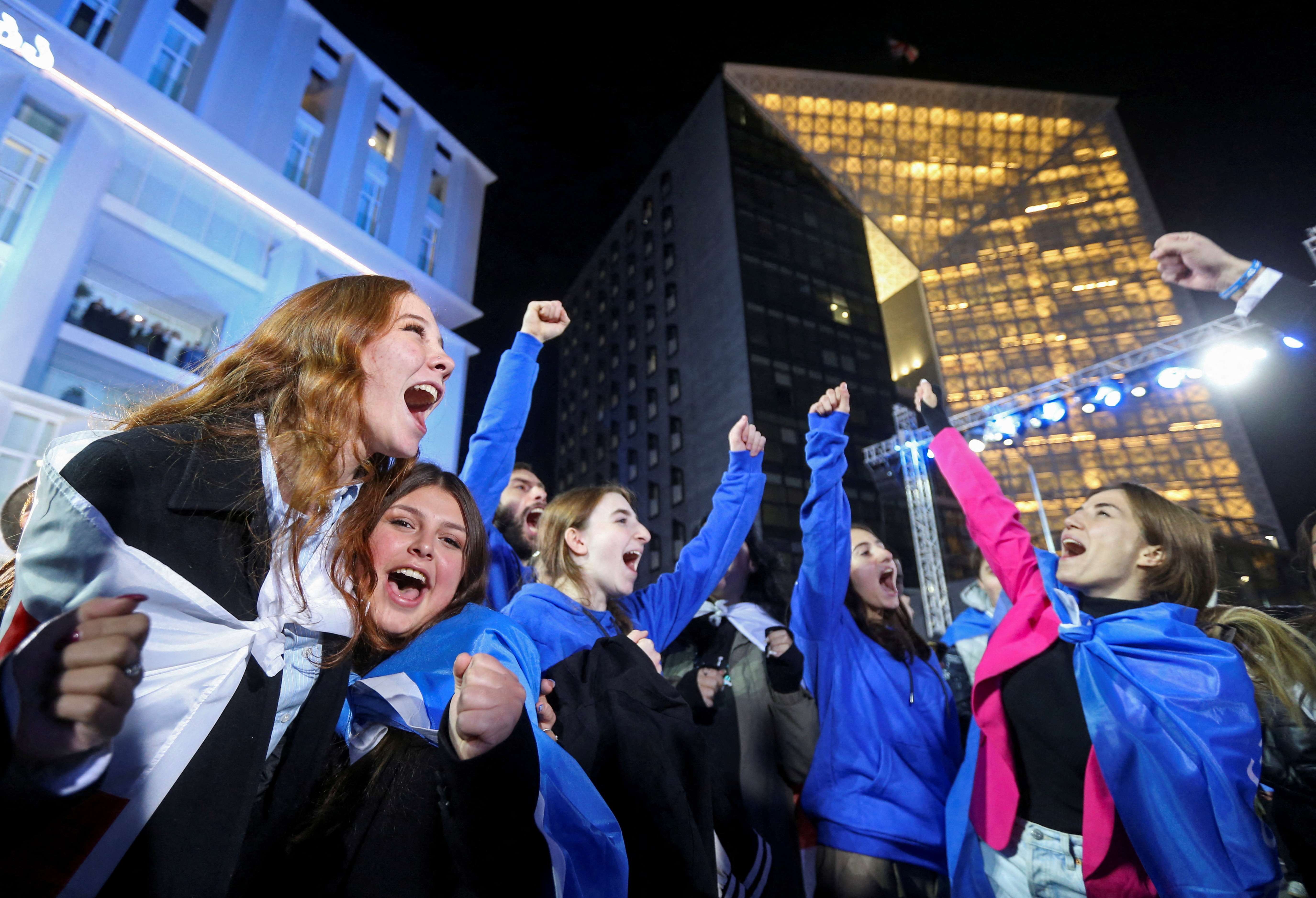 Simpatizantes do partido Sonho Georgiano comemoram anúncio de pesquisa de boca de urna em Tbilisi - 26/10/2024 (Foto: Irakli Gedenidze/Reuters)