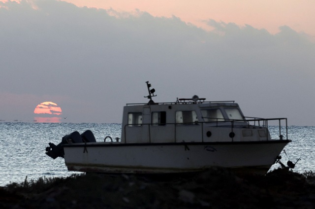 Um barco é visto diante de um nascer do sol na praia onde os sobreviventes do barco que naufragou na costa do Mar Vermelho, no Egito, ontem foram levados, em Marsa Alam, Egito, 26 de novembro de 2024. REUTERS/Mohamed Abd El Ghany