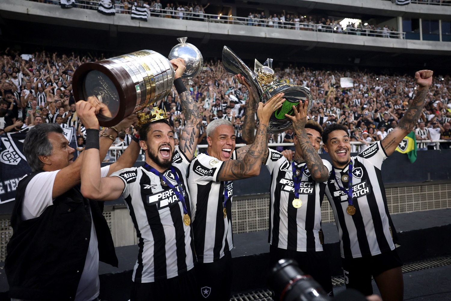 Jogadores do Botafogo posam para uma foto com o troféu do Campeonato Brasileiro e o troféu da Copa Libertadores diante dos torcedores. REUTERS/Ricardo Moraes