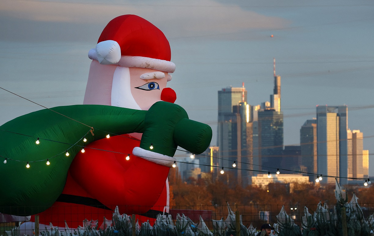 Uma enorme figura inflável do Papai Noel anuncia uma loja de árvores de Natal em frente ao horizonte de Frankfurt, na Alemanha, em 8 de dezembro de 2024 (REUTERS/Kai Pfaffenbach)