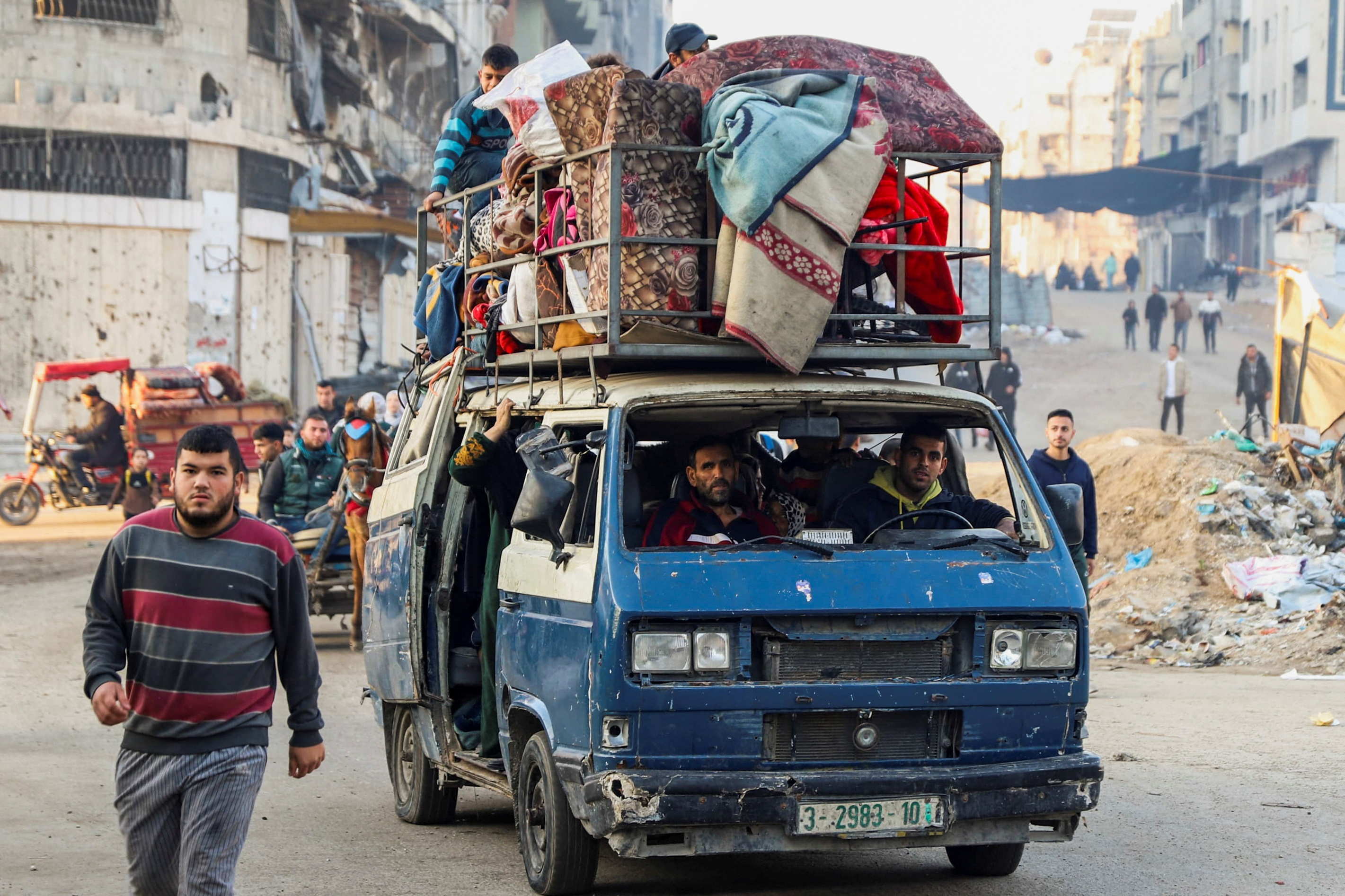 Palestinos deslocados com seus pertences em um veículo passam pelos escombros enquanto tentam retornar para suas casas após um atraso no cessar-fogo entre Israel e Hamas devido à lista de reféns, na faixa norte de Gaza, 19 de janeiro de 2025. REUTERS/Khalil Ramzi

