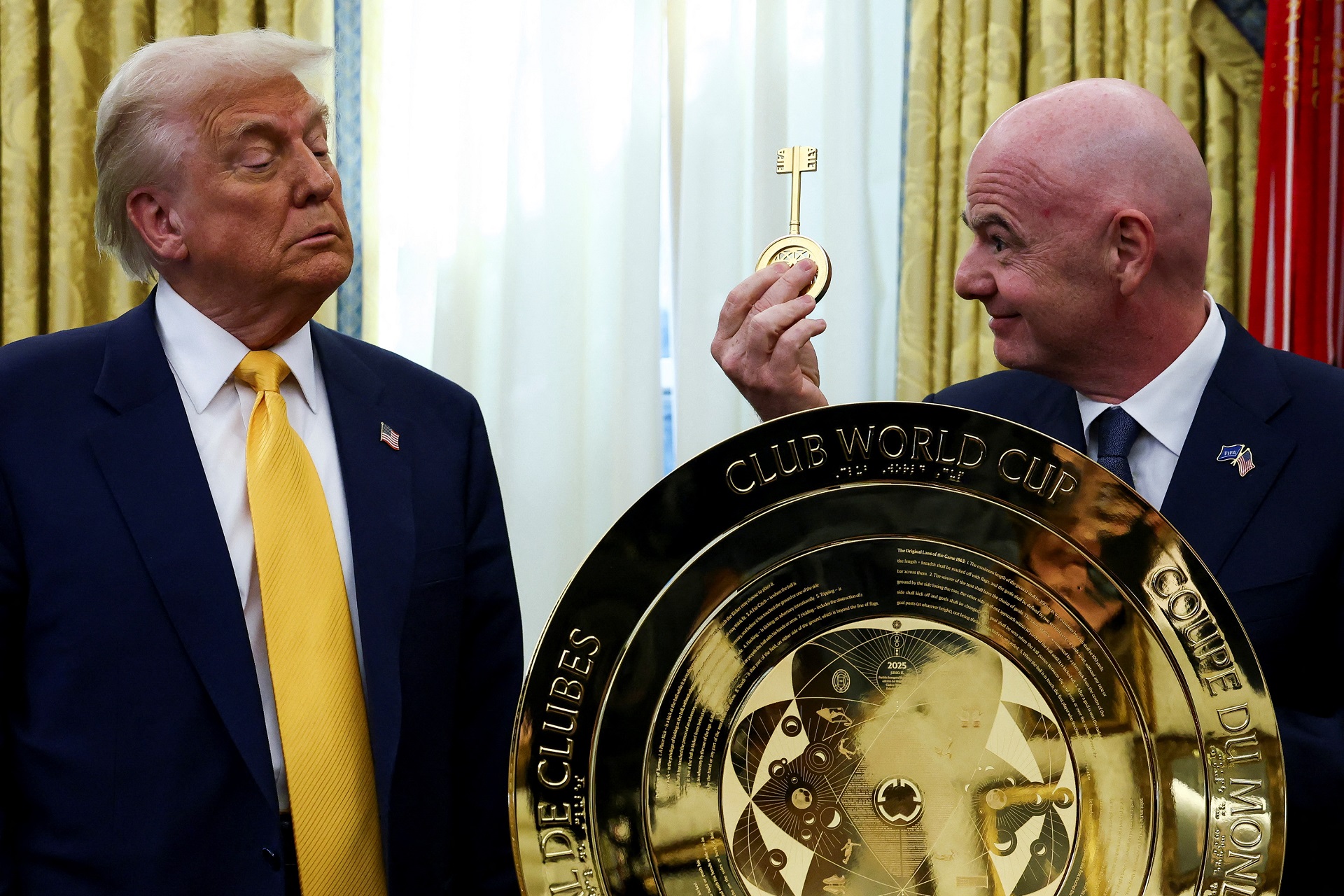 O presidente da FIFA, Gianni Infantino, segura a chave do troféu da Copa do Mundo de Clubes da FIFA ao lado do presidente dos EUA, Donald Trump, no Salão Oval da Casa Branca em Washington, D.C., EUA, 7 de março de 2025. REUTERS/Evelyn Hockstein